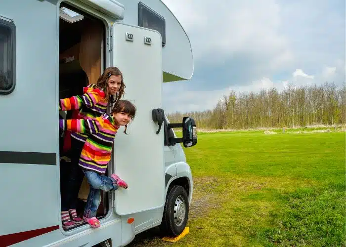 kids stand at motorhome door in striped sweaters