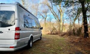 airstream interstate van parked in the woods