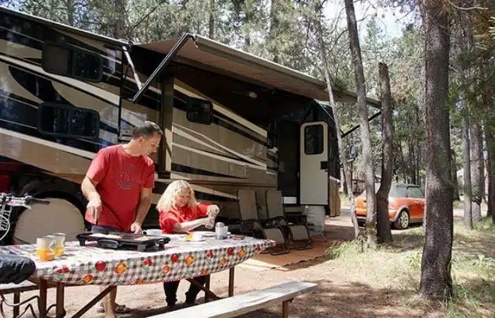 couple cooking breakfast at RV site in Thousand Trails Bend Oregon