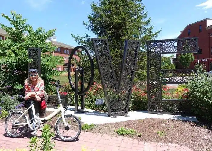 woman and bike in front of large LOVE sign