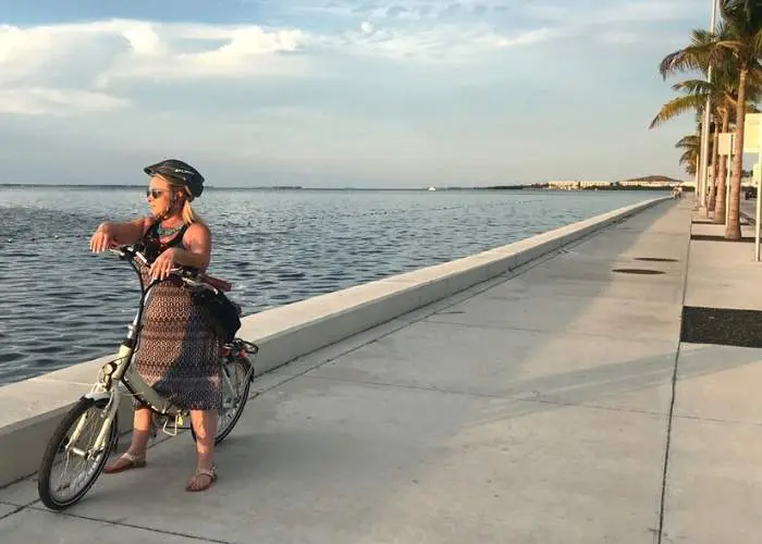 woman on blix bike on sidewalk near ocean in key west Florida