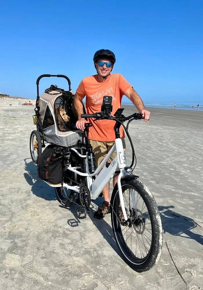 blix cargo ebike with rider and dog carrier at beach