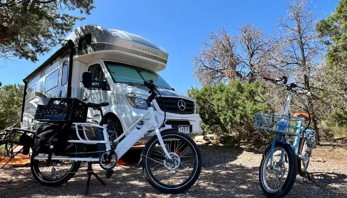 two ebikes in front of rv in campsite