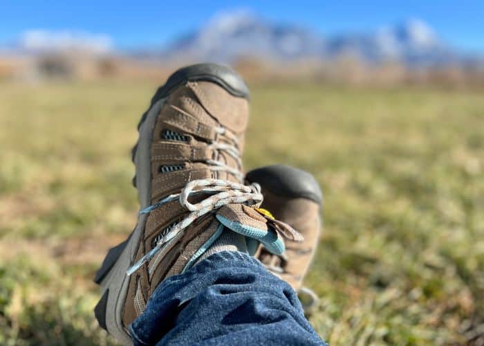 keen hiking shoes with green field and mtns