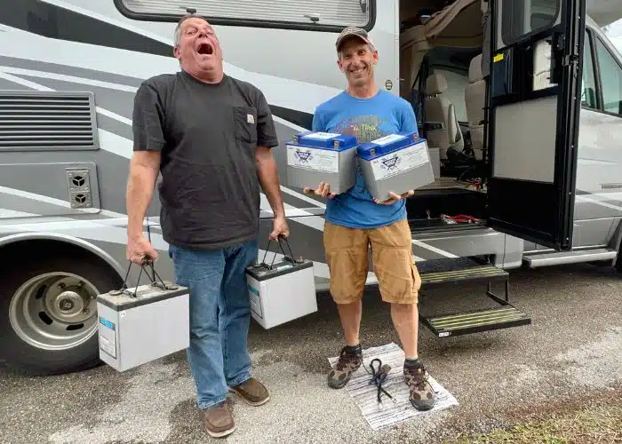 two guys holding batteries showing weight difference