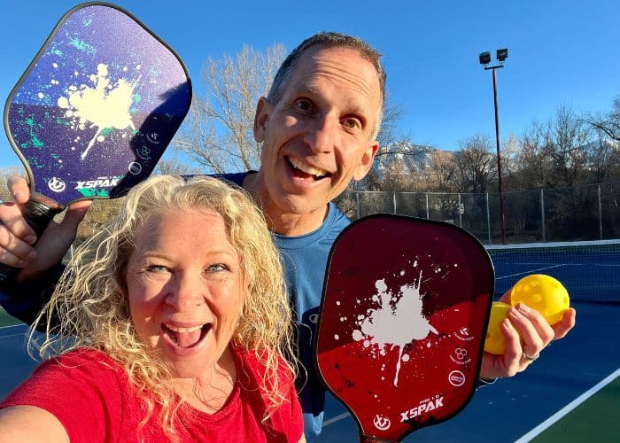 pickleball paddles and balls with man and woman