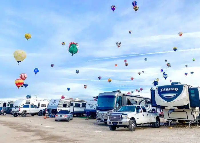 dozens of hot air balloons above rvs