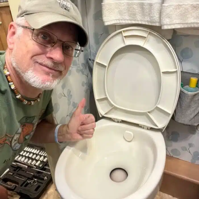 Man giving thumbs up after toilet repair
