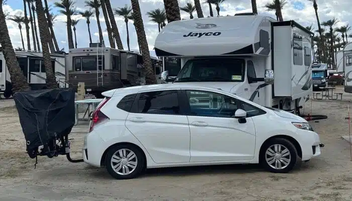 white honda fit with bike rack in front of jayco rv
