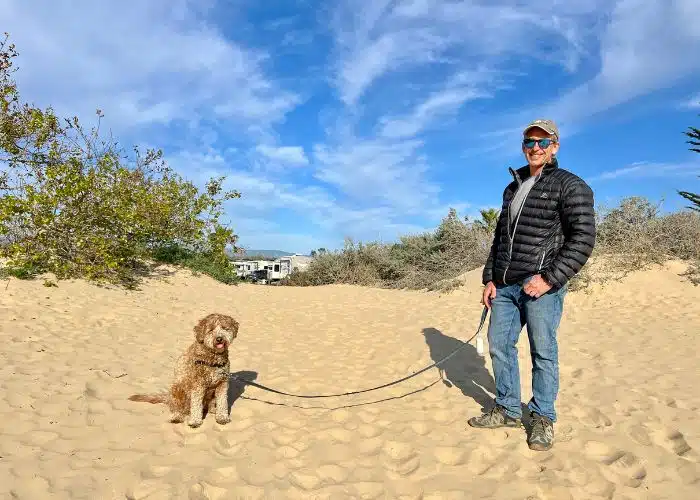 marc and dog sunny on sandy dune near campground