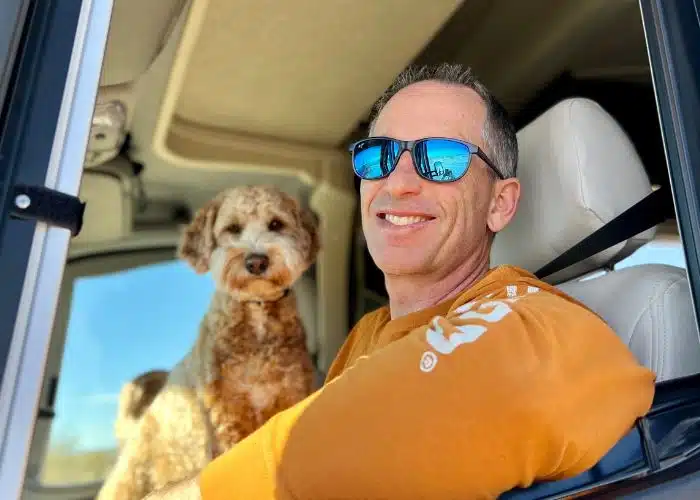 marc in rv driver seat with dog sunny in background