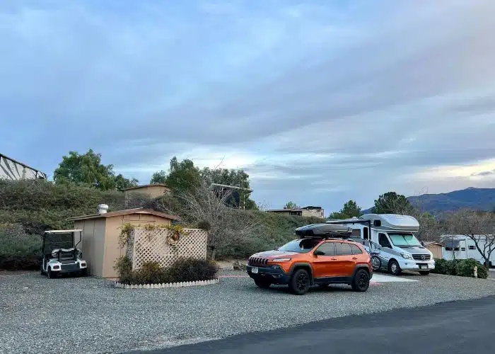 small class c rv and orange jeep cherokee parked in campsite at jojoba hills California