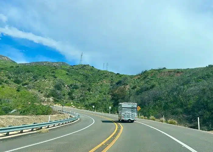 rv on road with green hillsides