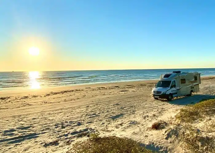 class c motorhome parked on beach rising sun golden sand