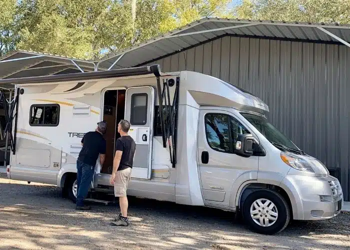 two men inspecting small motorhome