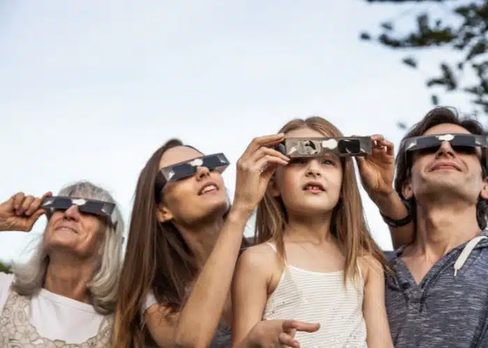 family viewing eclipse through special eclipse glasses