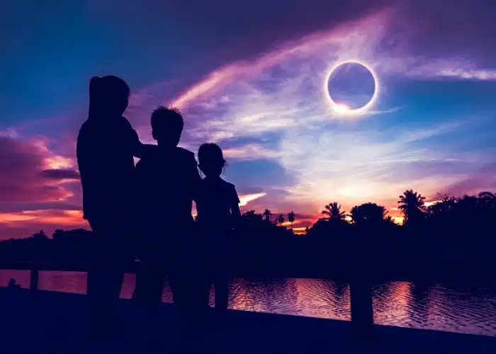 family watching eclipse night sky
