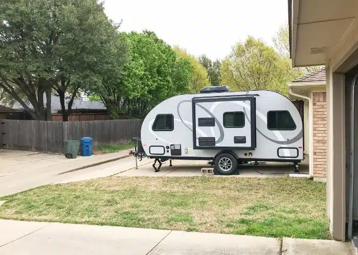 small trailer in driveway close to building side view