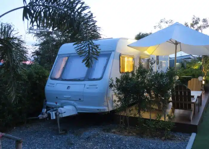 trailer parked tight against a deck in back yard