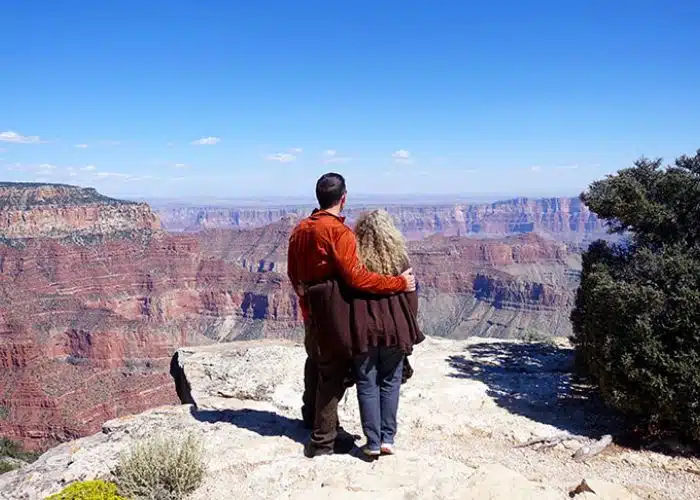 couple stands at edge of grand canyon