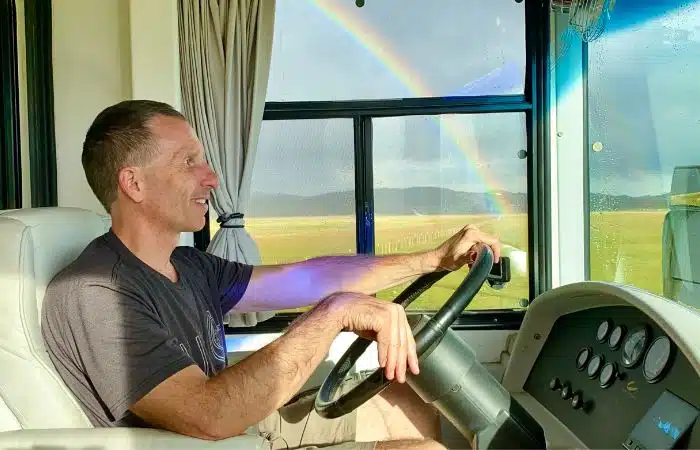 marc driving cc country coach motorhome rainbow behind