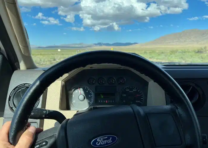 truck steering wheel with open road blue sky