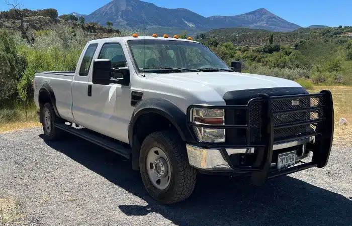 white ford f250 truck parked with mountains behind