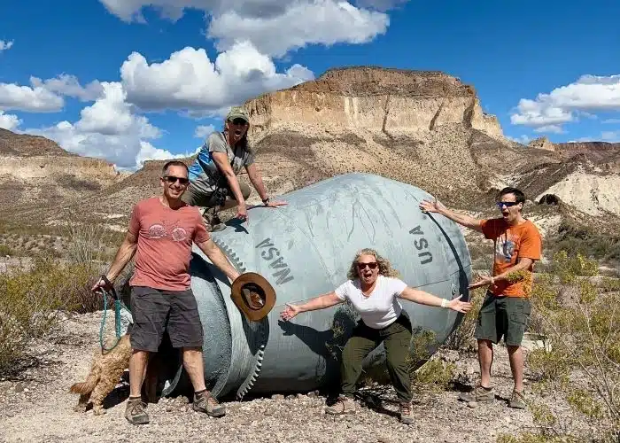 4 people and dog by NASA capsule and butte at big bend ranch state park