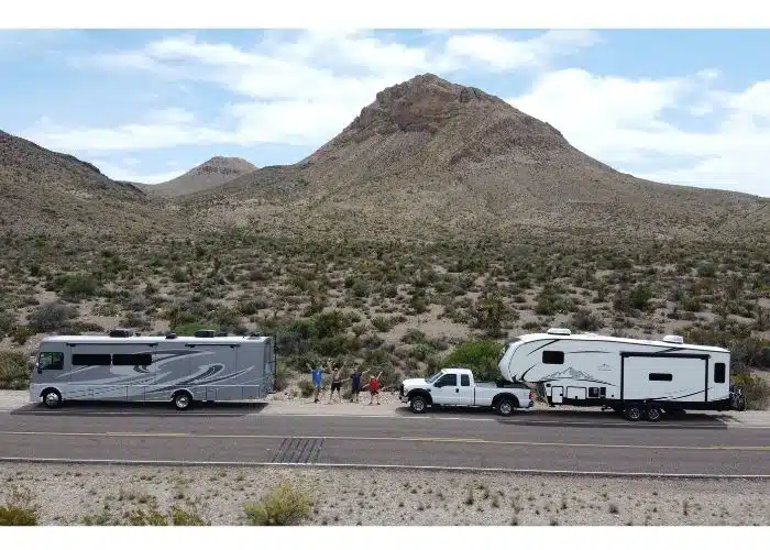 tour people stand in between rvs arms outstretched outside of. big bend national park tx