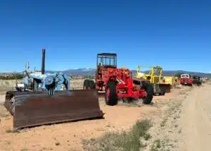 vintage farm equipment and vehicles parked at Santa Fe Skies RV Park NM
