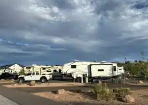 white truck and white fifth wheel parked. at campsite camp eddy grand junction co grey sky and clouds